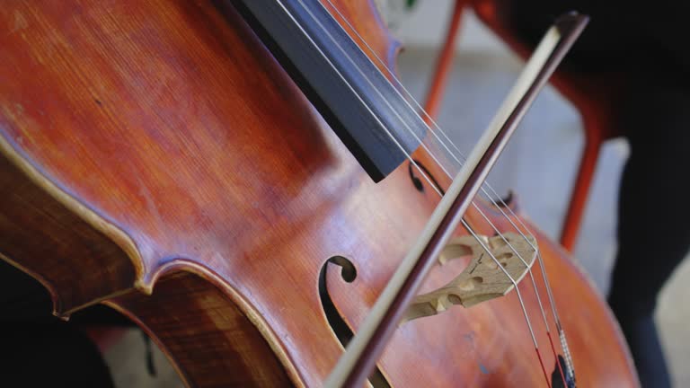 Woman playing cello on the stairs outdoors on the street