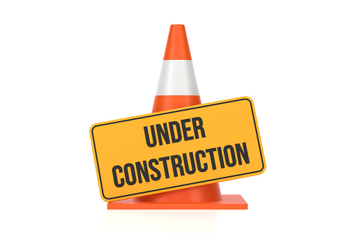 Traffic Cone And Under Construction Sign On White Background