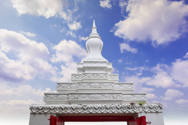 Thai temple archway with stucco decorations with clouds and sky background