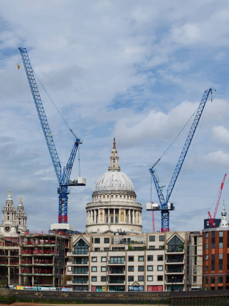 St Paul's Cathedral London framed by cranes  and construction work with a blue sky with light clouds