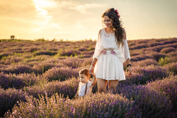 istock Mother and her son walking through lavender field at sunset 2137846135