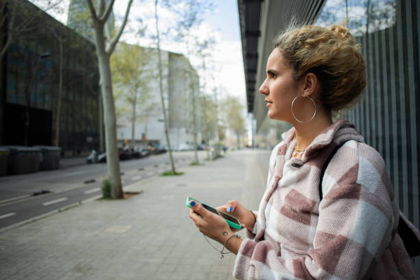 istock Young woman using a mobile phone outdoors 2137847681