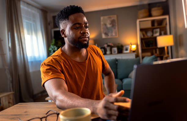 istock Young African American man sitting at home using laptop for video call. 2137866518