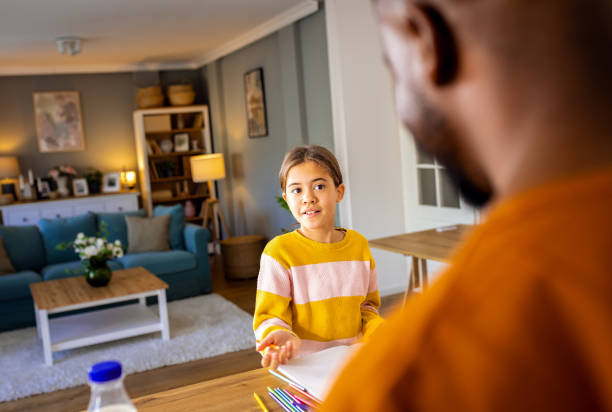 istock Girl is doing homework in the kitchen while her father preparing breakfast at home. 2137867056