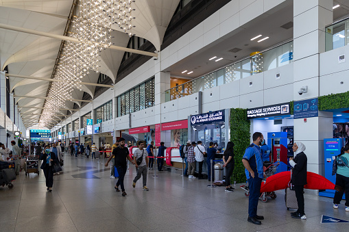 Dubai, United Arab Emirates - March 31, 2024 : People at the Dubai International Airport Terminal 1 in Dubai, United Arab Emirates.