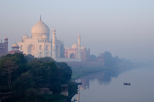 Taj Mahal, Yamuna river and boat during hazy morning, Agra, Uttar Pradesh, India.
