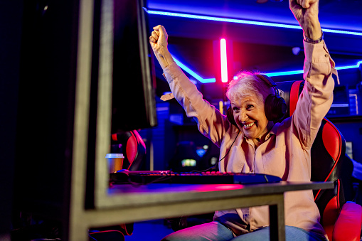 Senior Woman in Gaming Room At Night