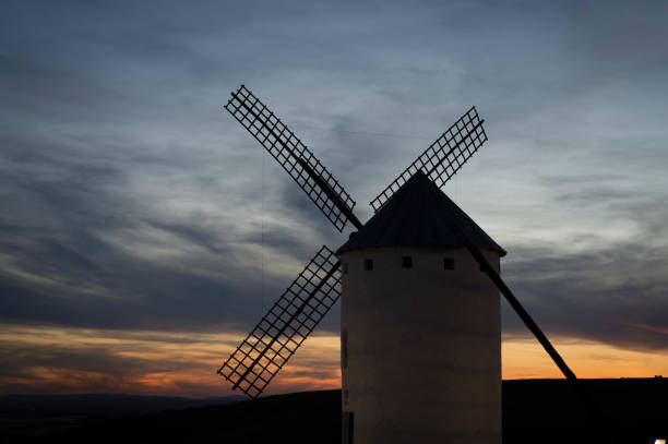 istock a very tall white windmill next to some mountains and clouds 2137926179