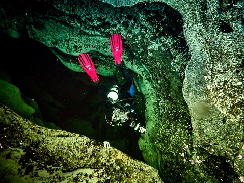 A local female scuba diver descents into the spring vent underwater at Blue Springs State Park, Volusia County, Florida