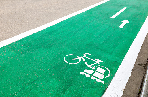 Dedicated green cycleway with bicycle and roller skates sign, designed to make cycling safer on the asphalt road