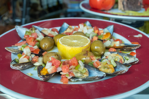 Mussels in vinaigrette Mediterranean dish. Delicious dish of mussels in vinaigrette, with lemon and green olives, a typical tapa in Spanish bars
