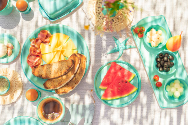 Picturesquely set breakfast table in Majorcan style, highlighting traditional turquoise crockery and Pa amb oli. Some over exposing because of the sunlight.