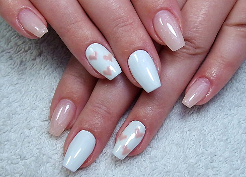 Person receiving manicure with marble nail art design