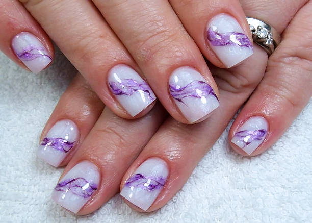 istock a person is holding a nail with purple and white designs on them 2137979122