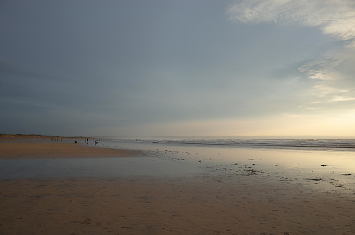 Peaceful England beach with a mix of sand, clouds and sea in pastel hues.