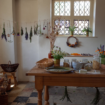 A vintage room with line dry flowers and herbs and pots of dried herbs on the table