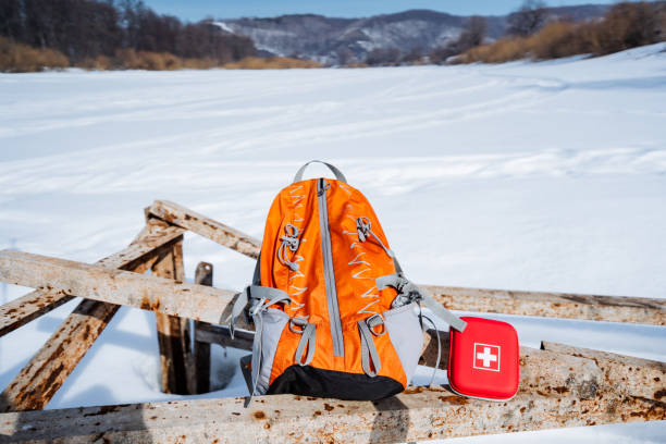 istock Hiking equipment for trekking, an orange backpack and a red first aid kit. 2138024455