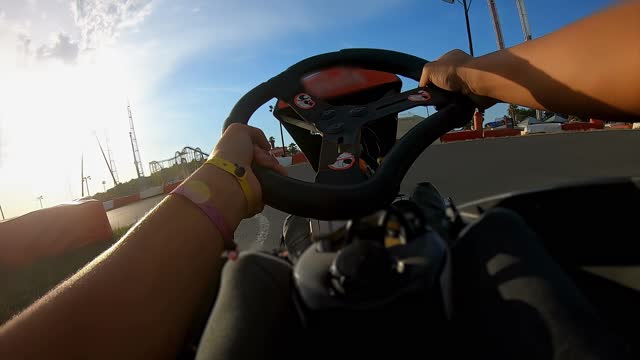 Man is driving a go-cart on the race track outdoors