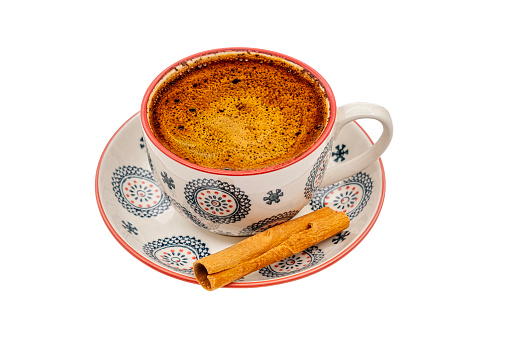 a cup of coffee with a stick of cinnamon on white background