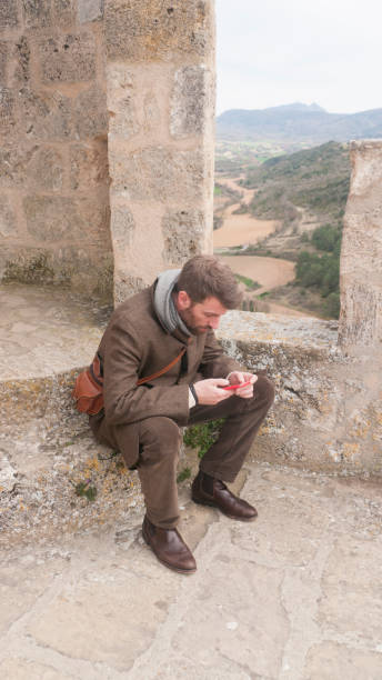 istock Man looking his smartphone in a castle tower 2138073070