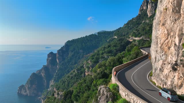 Motorcycle speeds through the curves overlooking the sea of the Amalfi Coast.