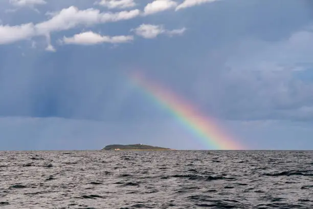 Rainbow and rain clouds, stormy skies over Hjelm Island, Kattegat, Denmark