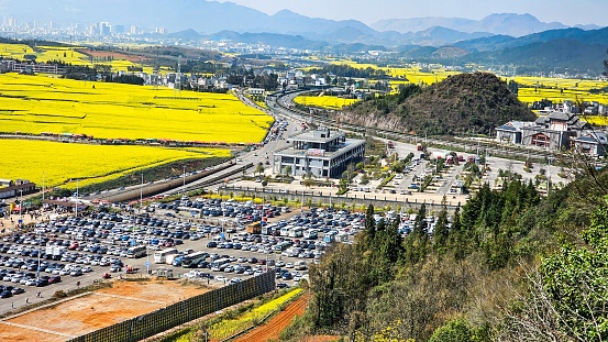 A scene of a busy parking lot and road filled with numerous vehicles in Loupin Rooster Hills, China