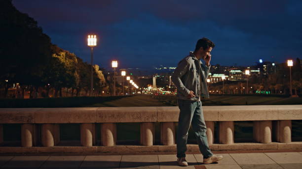 istock Positive guy speaking mobile phone at night city view. Smiling latin man talking 2138203524