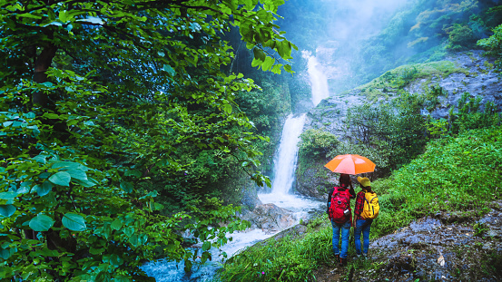 Lover asian man and asian women travel nature Travel the highest waterfall in Chiangmai Mae-pan waterfall rainy season at Doi intanon.