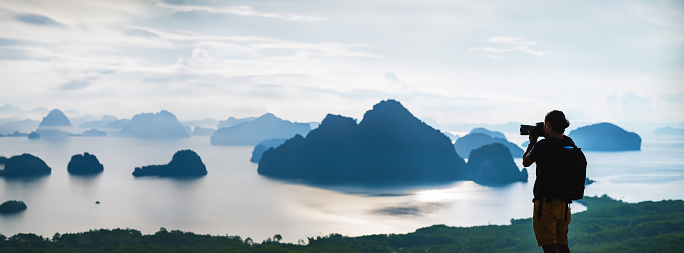 Men travel photography on the Mountain. Tourist on summer holiday vacation. Landscape Beautiful Mountain on sea at Samet Nangshe Viewpoint. Phang Nga Bay , Travel Thailand, Travel adventure nature.
