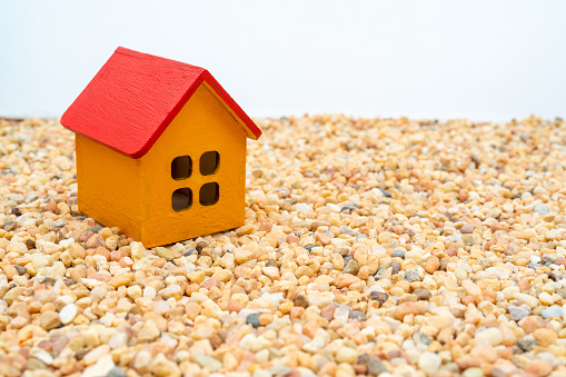 Model of a wooden yellow house with a red roof. Rent and sale of buildings and cottages.