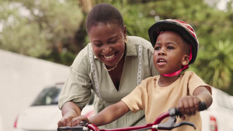 Learning, mother and boy with a bike, help and teaching with guidance and child development. Family, outdoor and cycling with happiness and love with kid and son with mama and bicycle with growth