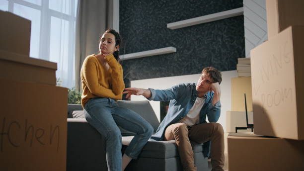 istock Couple rest moving house feeling exhausted. Spouses sitting couch with boxes. 2138263862