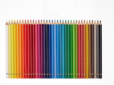 Alignment of colored pencils on white background