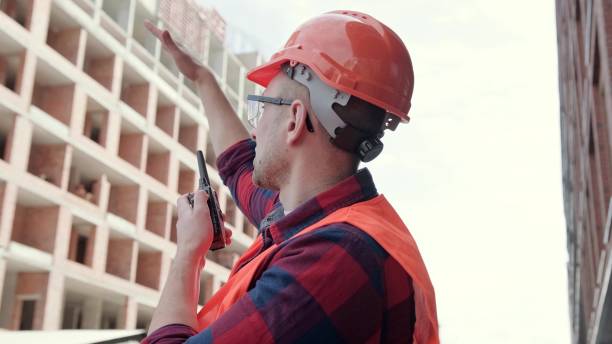 istock Foreman using walkie-talkie for coordination of building site works 2138292105