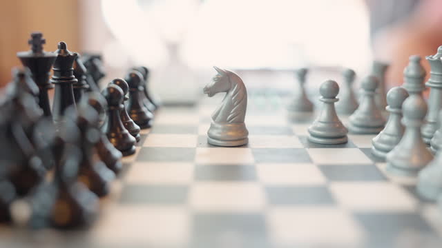 A Man Moving Chess Piece In A Board Game