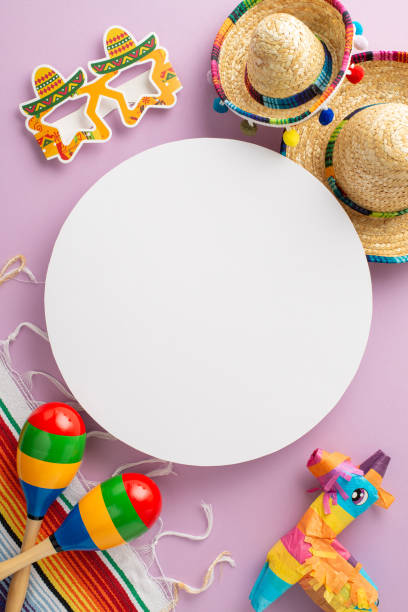 istock Cinco de Mayo celebration concept with a vertical top view of characteristic elements: festive hats, maracas, a vibrant serape, and other decorations, set on pastel violet background with blank circle 2138301192