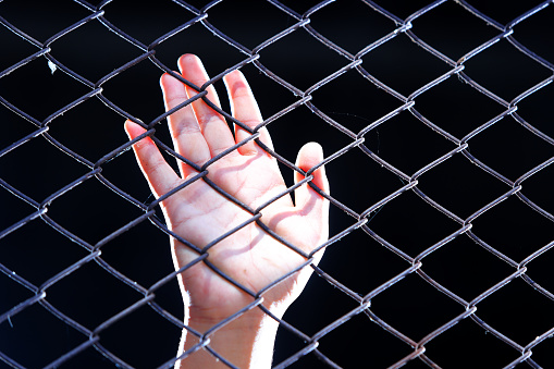 close up of hand in jail as background