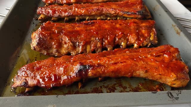 Serving fresh and hot oven baked pork ribs on a baking sheet