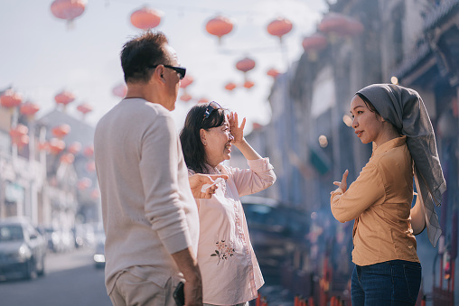 Local tour guide explaining to tourist chinese couple on Penang chinese new year celebration and culture