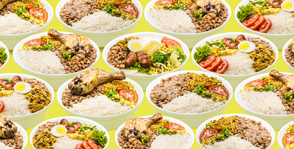 marmita or marmitex, Brazilian home-delivered lunch meal, with rice, sausage, farofa and salad, beans, copy space, yellow background