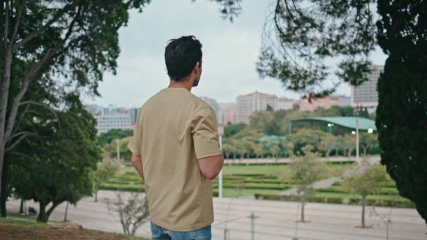 istock Attractive guy resting park holding coffee cup. Hispanic man drinking beverage 2138338809