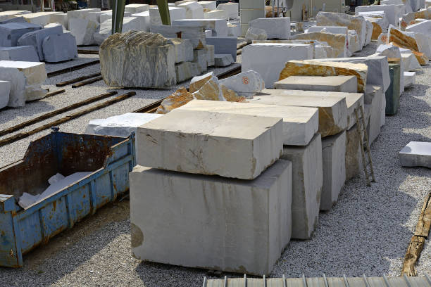 Many large rectangular blocks of white Carrara marble outdoors in Tuscany, Italy