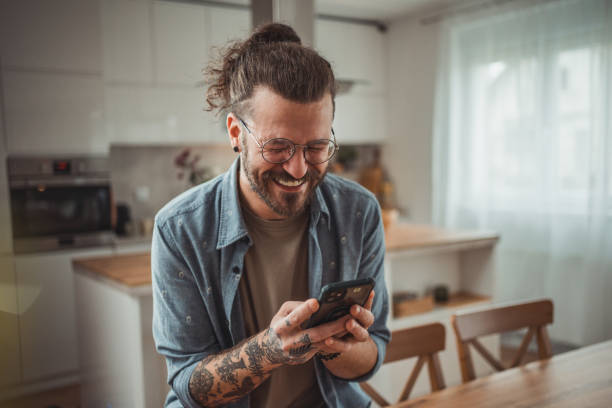 istock Happy man using mobile phone while in his apartment, surfing internet or sending sms message 2138371141
