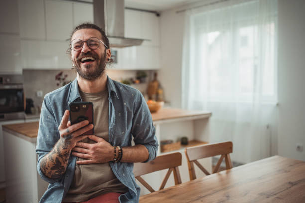 istock Happy man using mobile phone while in his apartment, surfing internet or sending sms message 2138371146