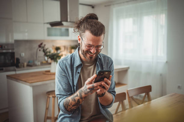 istock Happy man using mobile phone while in his apartment, surfing internet or sending sms message 2138372690