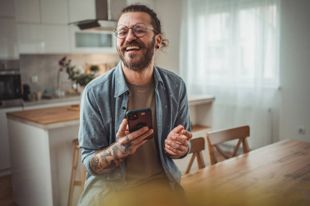 istock Happy man using mobile phone while in his apartment, surfing internet or sending sms message 2138372692