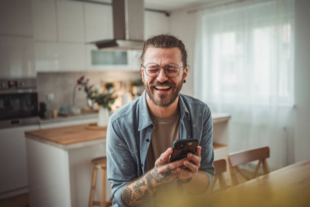 istock Happy man using mobile phone while in his apartment, surfing internet or sending sms message 2138372700