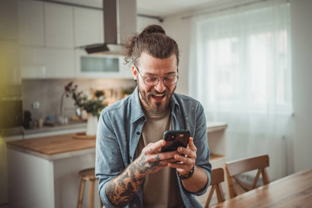 istock Happy man using mobile phone while in his apartment, surfing internet or sending sms message 2138373213