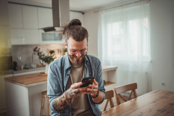 istock Happy man using mobile phone while in his apartment, surfing internet or sending sms message 2138373214